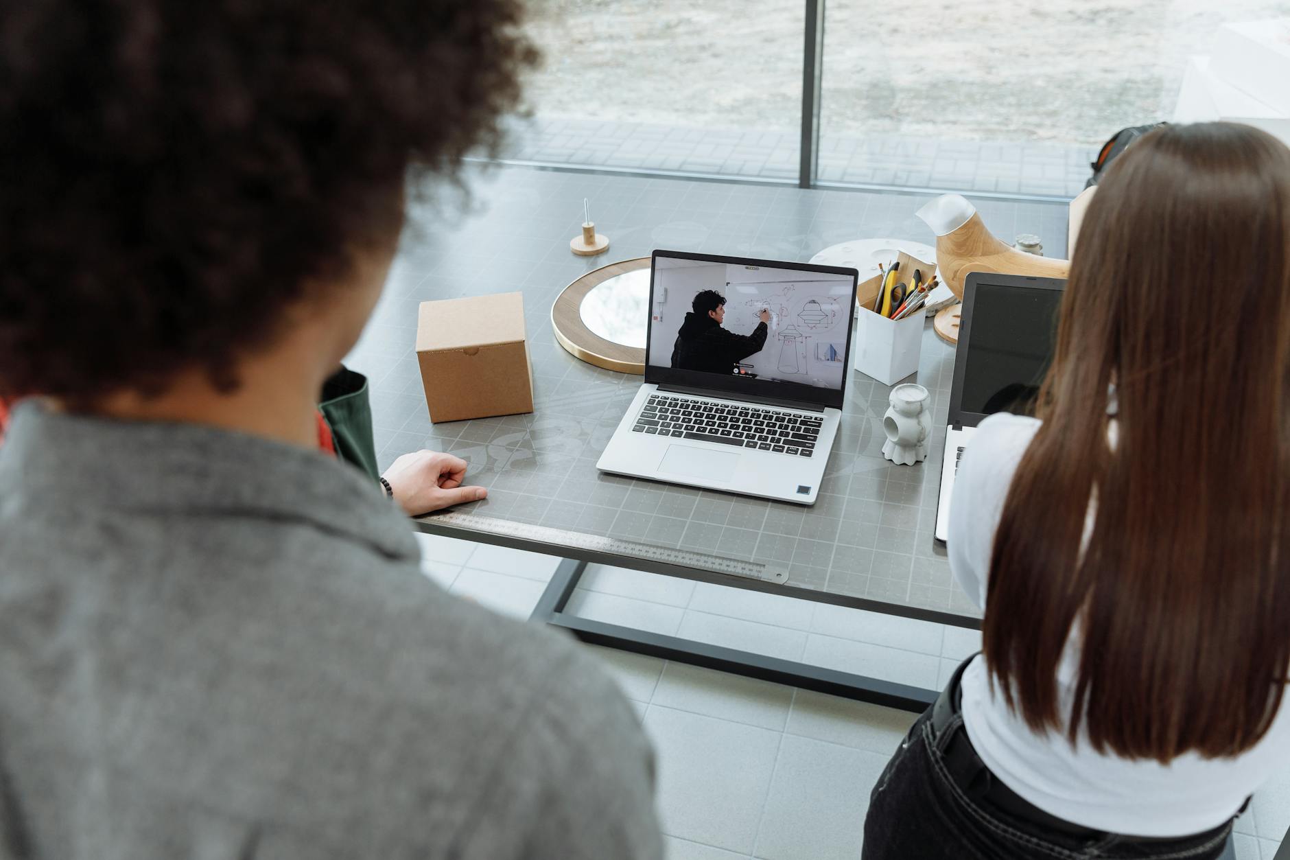 Hybrid team in a Microsoft Teams meeting using Copilot on a laptop in a Singapore office