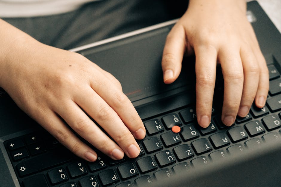 Hands typing a formula on a laptop keyboard