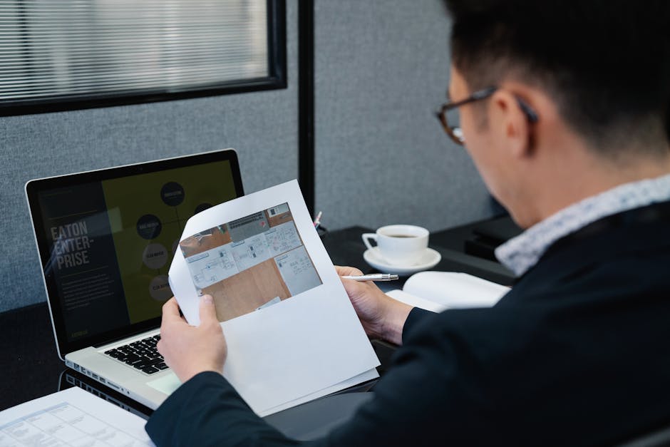 Office worker in a modern Singapore workplace reviewing data on a laptop