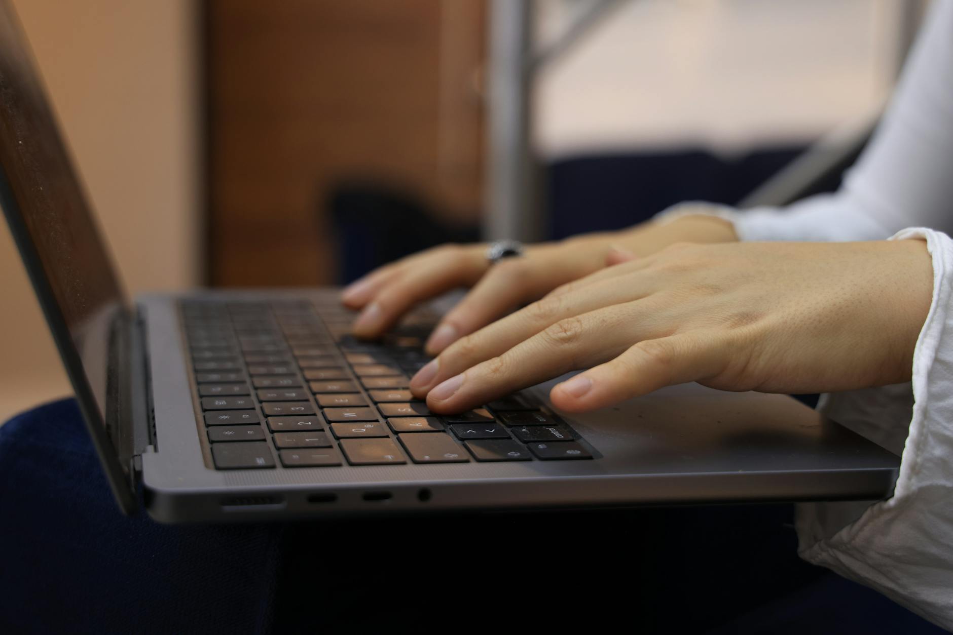 Close-up of hands typing on a laptop keyboard with the Alt key visible