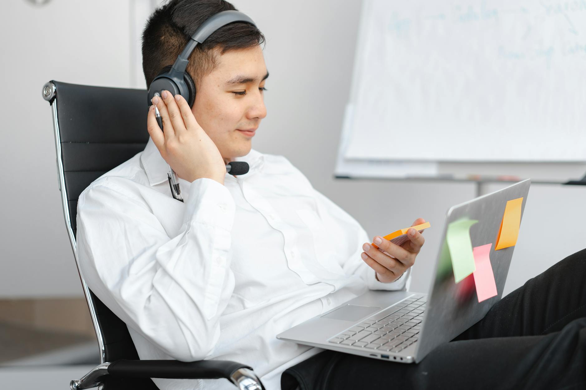 A person in a headset using Copilot to take meeting notes on a laptop during an online Teams call