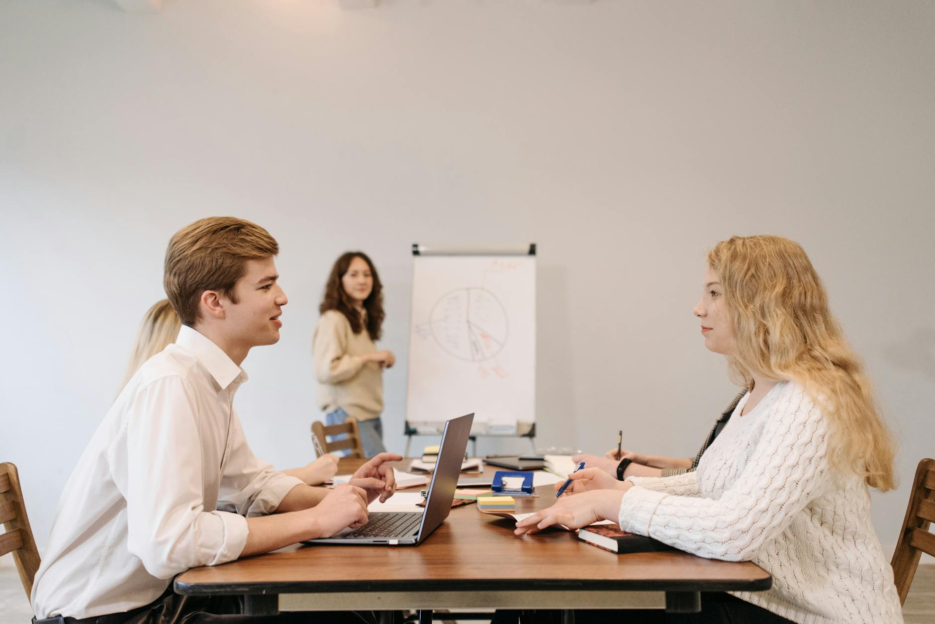 A presenter showing slides to colleagues in a small conference room