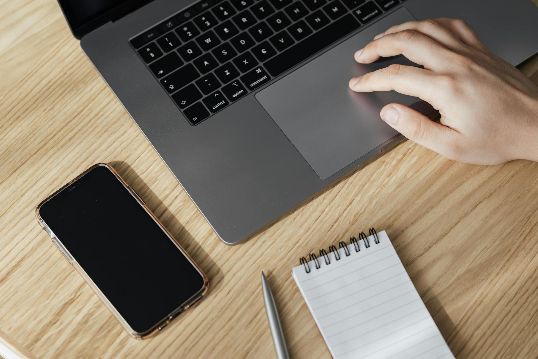 Hand using a laptop trackpad to apply a transition setting in PowerPoint