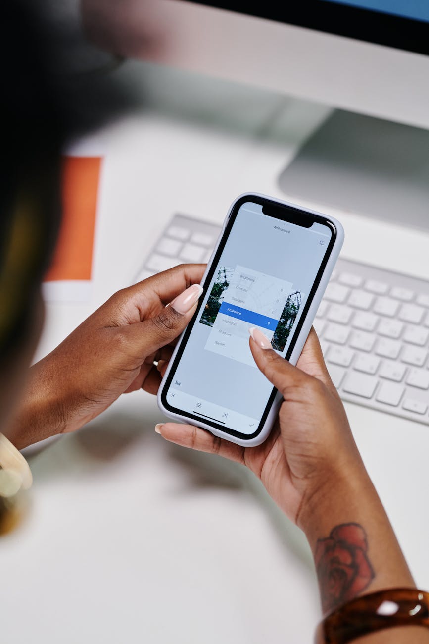 A young woman using the Canva mobile app on her smartphone to edit a design