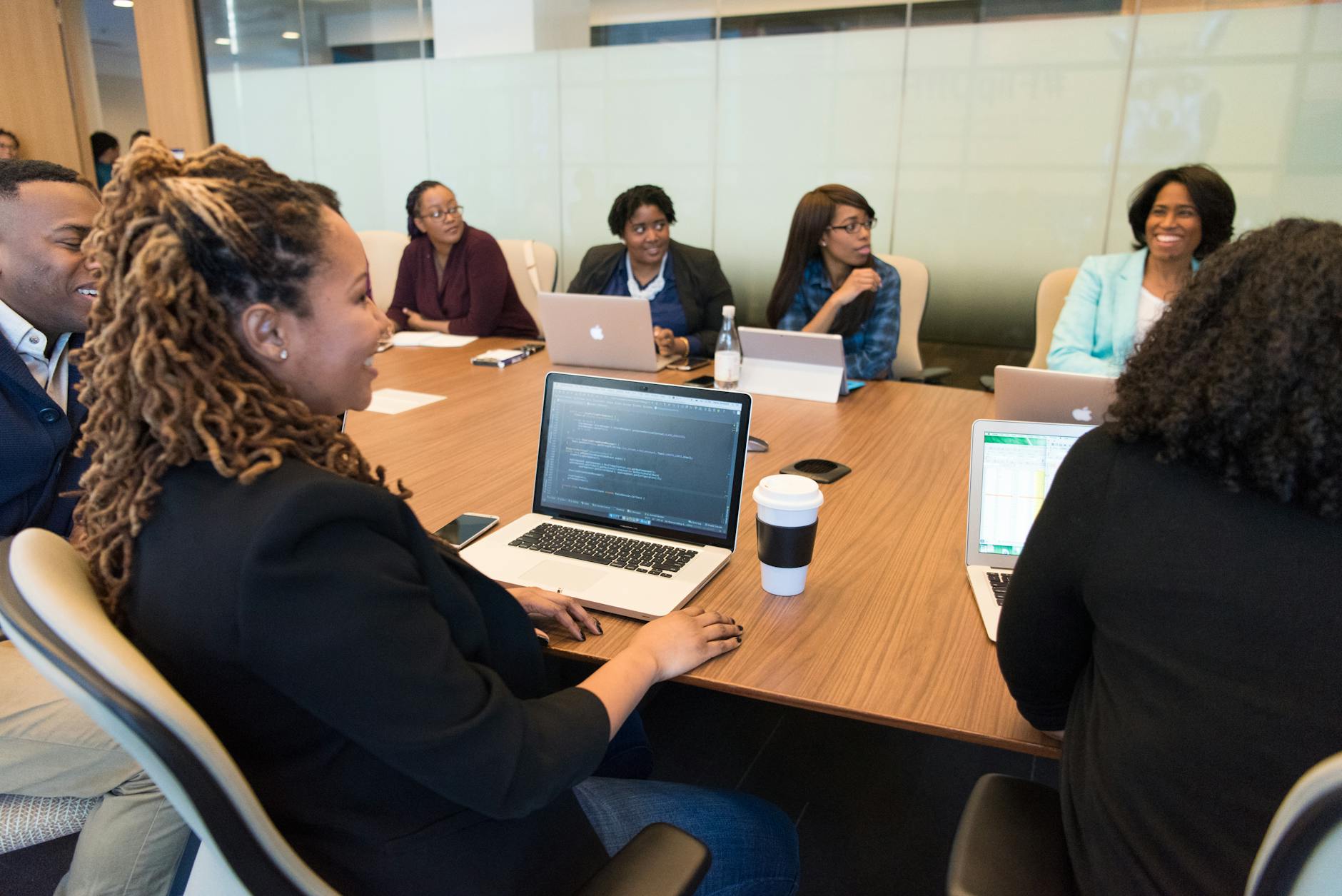 A Singapore business team using Copilot in Microsoft 365 apps on laptops in a meeting room